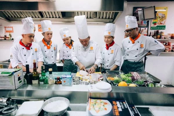 Trung Cấp Kỹ Thuật Chế Biến Món Ăn 5 Đầu bếp chuyên nghiệp đang chế biến món ăn tại nhà hàng khách sạn sau khi tốt nghiệp trung cấp chế biến món ăn